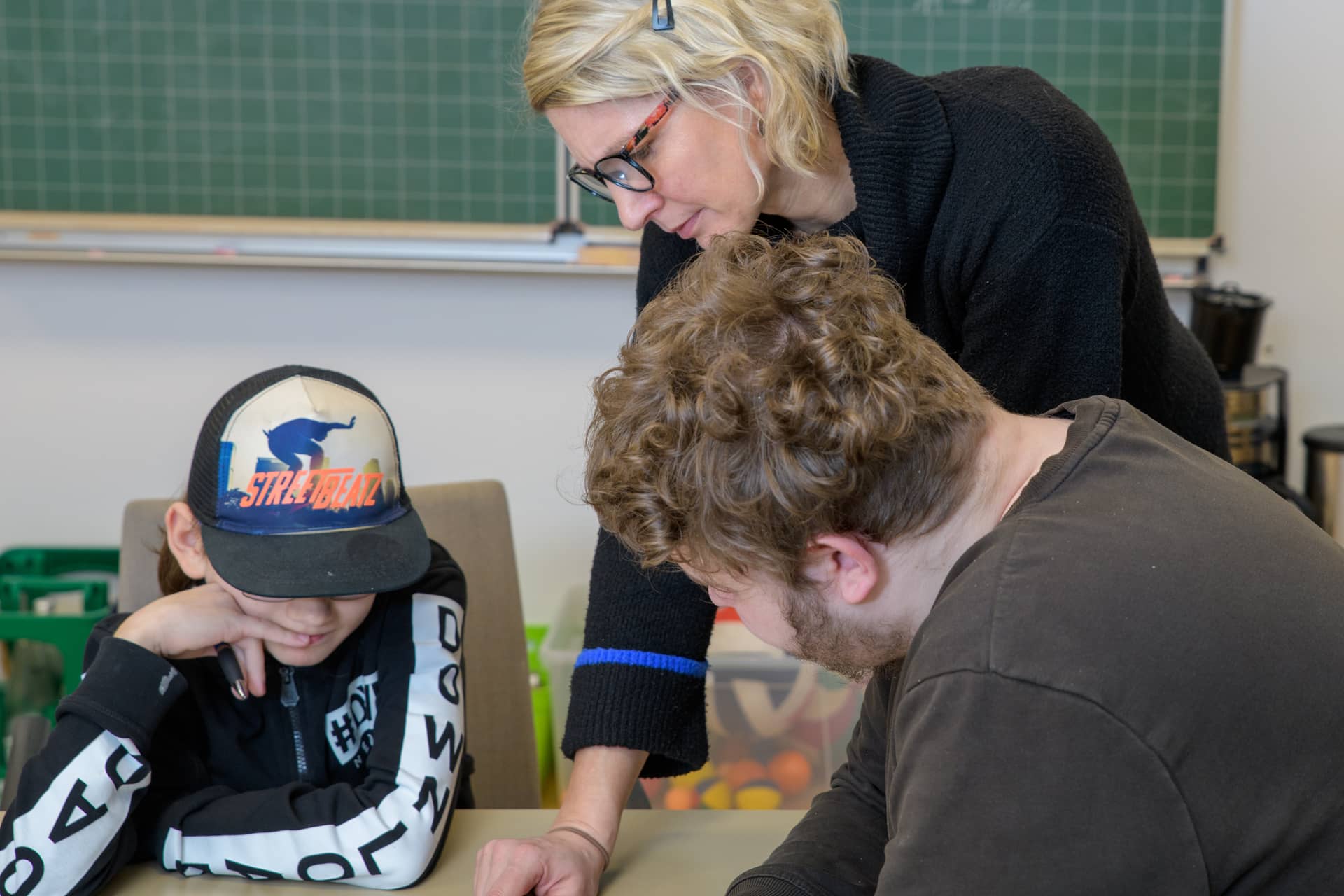 Pädagogische Fachkraft unterstützt Jugendliche bei Lösungen von Aufgaben im Rahmen der Tagesstrukturangebote bei der Karl Immanuel Kuepper-Stiftung