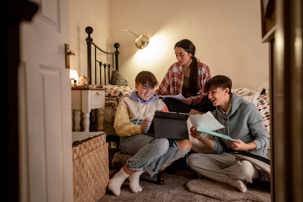 Intensivpädagogische Verselbstständigung bei der Karl Immanuel Kuepper-Stiftung - drei Jugendliche hocken in einem Zimmer zusammen